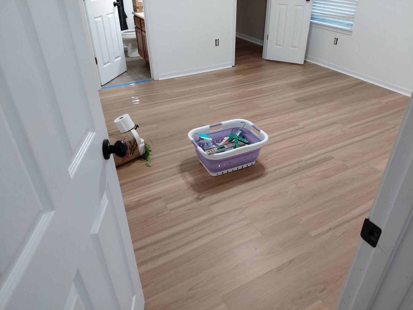 Plank flooring run through a hallway and into adjoining rooms