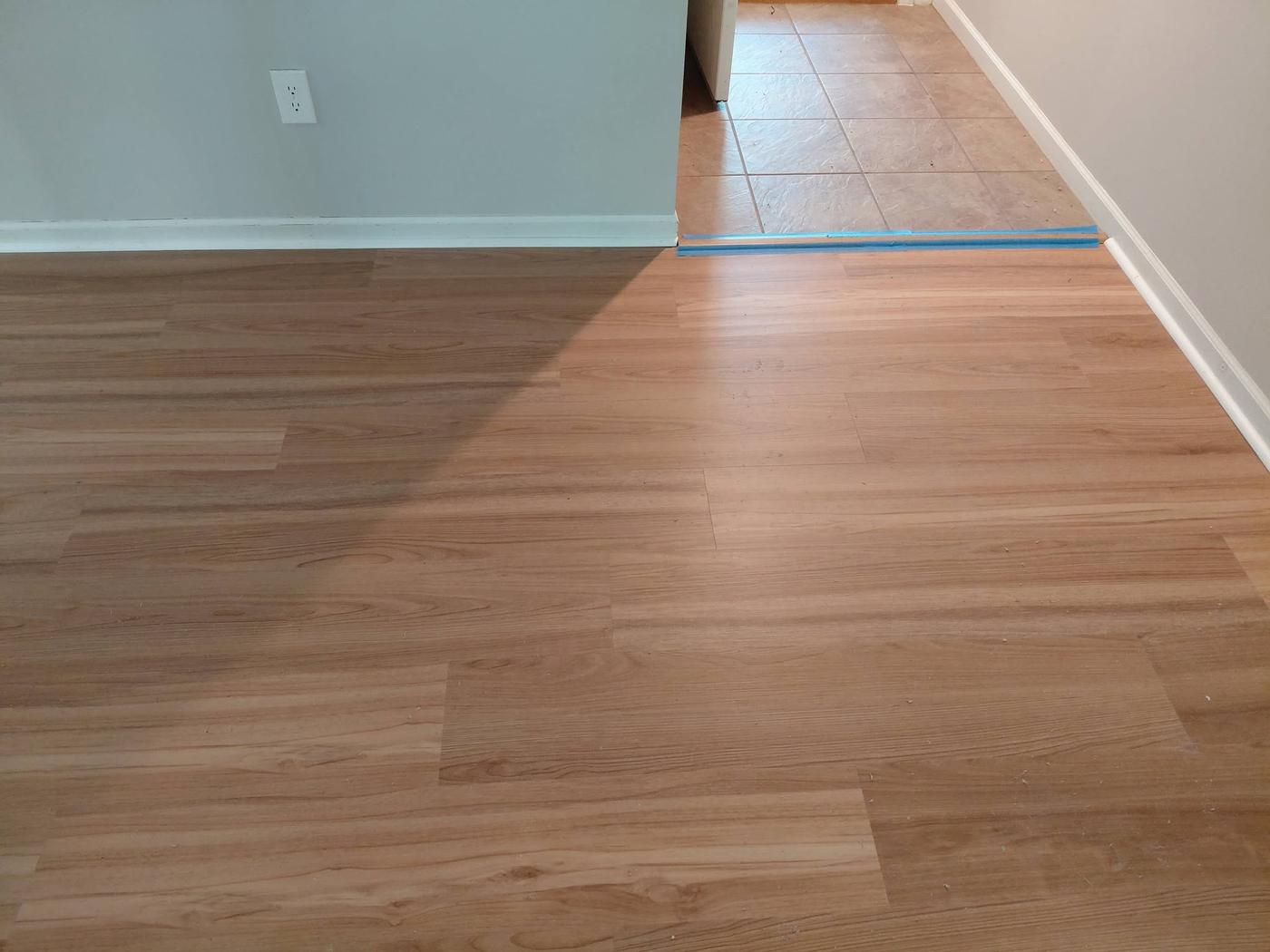 Plank floor meeting an existing tile floor at a doorway